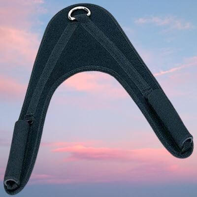 Accessoire de musculation en forme de V inversé, avec structure renforcée en mousse noire et anneau métallique au sommet. Utilisé pour les exercices de crunch et de renforcement abdominal. L’arrière-plan avec ciel rose et bleu donne un effet esthétique au