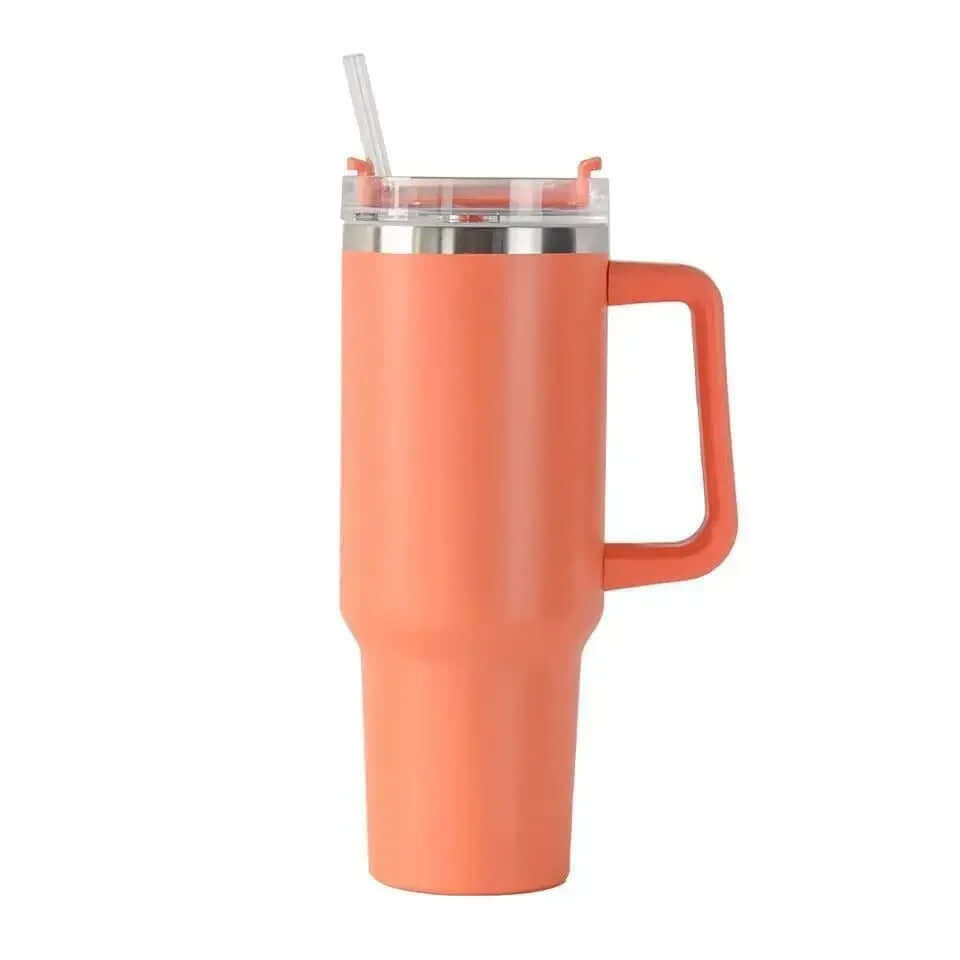 Un accessoire d’un orange vif avec un revêtement mat et une structure élancée. Son anse latérale est robuste et intégrée au design. Le couvercle transparent dispose d’une ouverture pour une paille fine. L’arrière-plan beige apporte un équilibre visuel en 